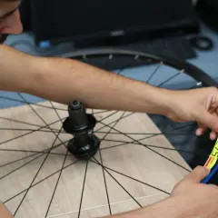 Mechanik sprawdza rozmiar koła rowerowego 27.5 cala. Sprawdź decathlon serwis rowerowy cennik dla usług.