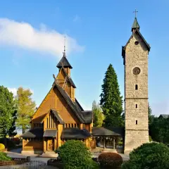 Drewniany kościółek i kamienna wieża z zegarem. Idealne miejsce na spokojny weekend w Karpaczu.