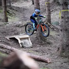 Chłopiec na rowerze skacze przez przeszkodę w lesie. To rower dla 7 latka, ile cali?