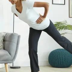 Kobieta w ciąży ćwiczy pilates, unosząc nogę. Dba o formę i dobre samopoczucie.