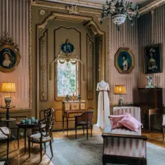 Wnętrze pałacu w Nieborowie. Elegancki salon z portretami, meblami i manekinem w sukni.
