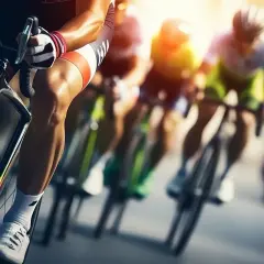 Wyścig **bikery** w pełnym słońcu. Kolarze w aerodynamicznych strojach pędzą po trasie, skupieni na rywalizacji.