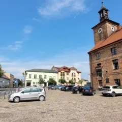 Rynek w Połajewie z ratuszem i kolorowymi kamienicami.