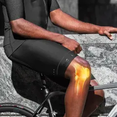 Ból kolan to jeden z negatywnych skutków jazdy na rowerze. Widoczny rowerzysta z podświetlonym stawem kolanowym.