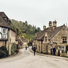 Kamienna zabudowa i brukowana droga w malowniczej wiosce Cotswolds.