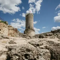 Kamienna wieża i ruiny zamku w Iłży pod błękitnym niebem z chmurami.