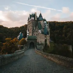Kamienny most prowadzi do malowniczego zamku Eltz, jednego z najpiękniejszych zamków w Niemczech, otoczonego jesiennym lasem.