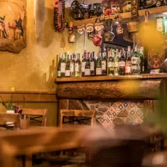 Drewniany bar w Szklarskiej Porębie Rynek, pełen butelek wina i ozdób.
