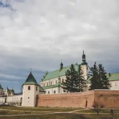 Klasztor w Leżajsku, jedna z głównych atrakcji, z zielonymi dachami i ceglanym murem.