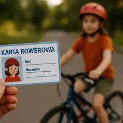 Karta rowerowa od ilu lat? Dziecko w kasku jedzie na rowerze, a ręka trzyma kartę rowerową z rysunkiem dziewczynki.
