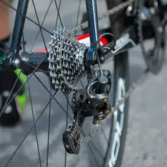 Jak naciągnąć łańcuch w rowerze z przerzutkami Shimano? Widok tylnego koła z kasetą i przerzutką.