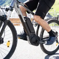 Widok z bliska na rower elektryczny w ruchu. Widać pedały, baterię i silnik, co pokazuje, jak działa rower elektryczny.