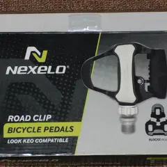 Pudełko z pedałami rowerowymi Nexelo. Czarno-białe opakowanie z żółtym akcentem i grafiką pedału.
