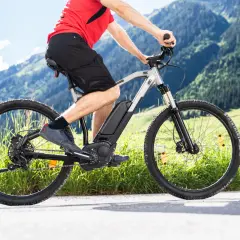 Mężczyzna na rowerze elektrycznym w górach. Zastanawiasz się, jaki rower elektryczny wybrać? Ten model świetnie sprawdzi się na górskich trasach.