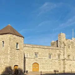 Kamienne budowle w southampton miasto, z wieżą i bramą, pod błękitnym niebem.