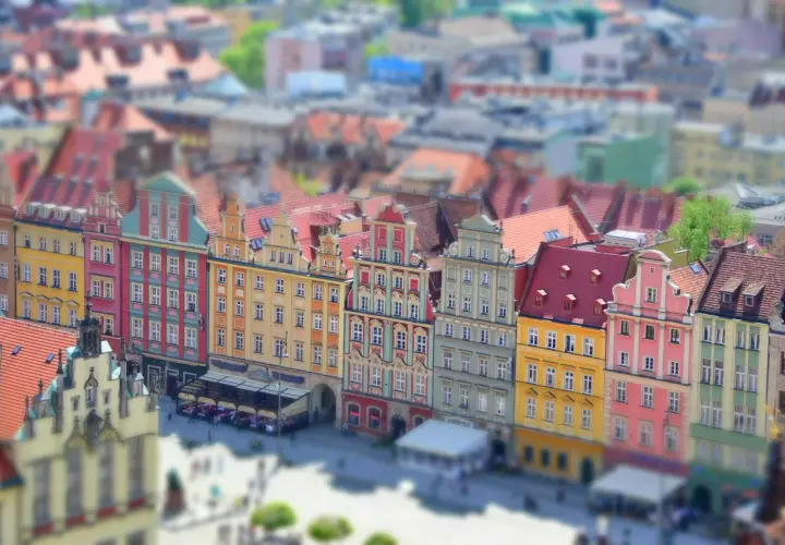 Kolorowe kamienice na starym rynku we Wrocławiu, z widokiem na dachy i plac.