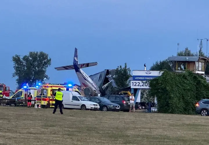Wypadek na lotnisku Chrcynno. Rozbity samolot, wozy strażackie, karetki i policja na miejscu zdarzenia.