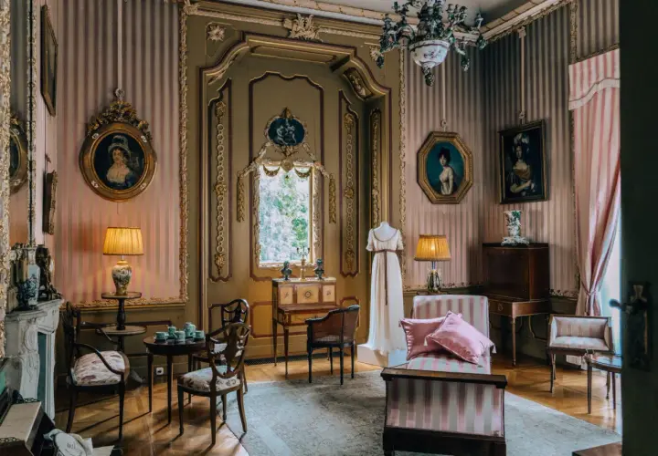 Wnętrze pałacu w Nieborowie. Elegancki salon z portretami, meblami i manekinem w sukni.
