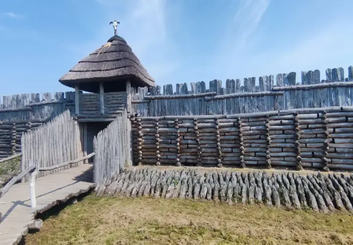 Drewniany gród obronny, przypominający rekonstrukcję osady z epoki brązu, z charakterystyczną wieżą i palisadą. To właśnie tutaj znajduje się Janowiec Wielkopolski.