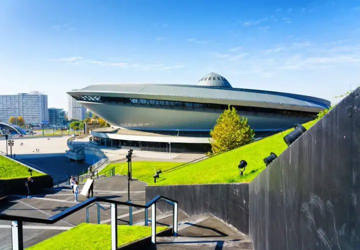 Spodek w Katowicach, ikona województwa śląskiego, otoczony zielenią i nowoczesną architekturą.