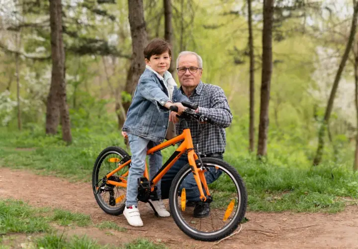 Chłopiec na rowerze 20 cali na jaki wzrost? Dziadek z wnukiem na leśnej ścieżce, gotowi na wspólną przejażdżkę.