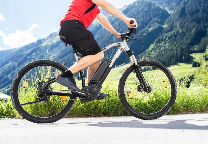 Mężczyzna na rowerze elektrycznym w górach. Zastanawiasz się, jaki rower elektryczny wybrać? Ten model świetnie sprawdzi się na górskich trasach.