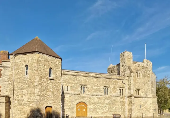Kamienne budowle w southampton miasto, z wieżą i bramą, pod błękitnym niebem.
