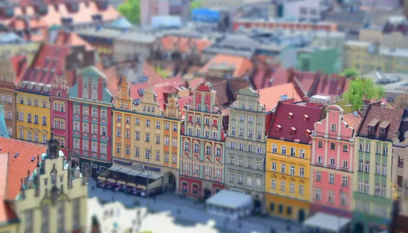 Kolorowe kamienice na starym rynku we Wrocławiu, z widokiem na dachy i plac.