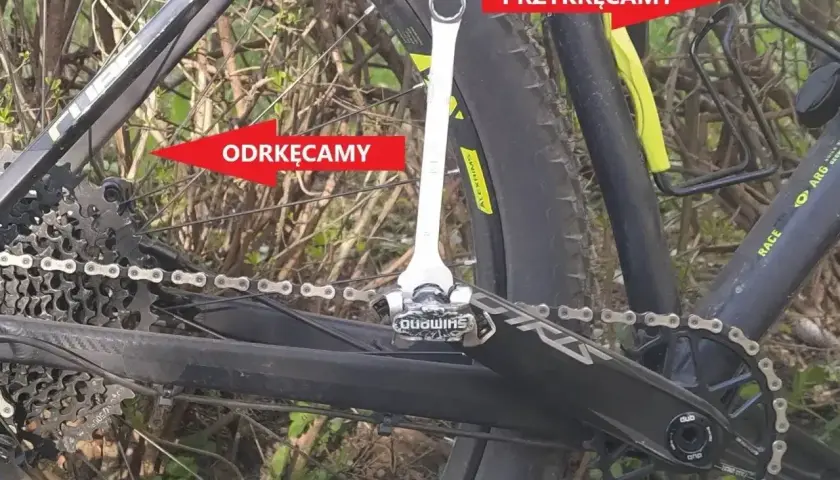 Klucz do pedałów pokazuje, jak rozkręcić pedały w rowerze. Strzałka "odkręcamy" wskazuje na lewy pedał, a "przykręcamy" na prawy.