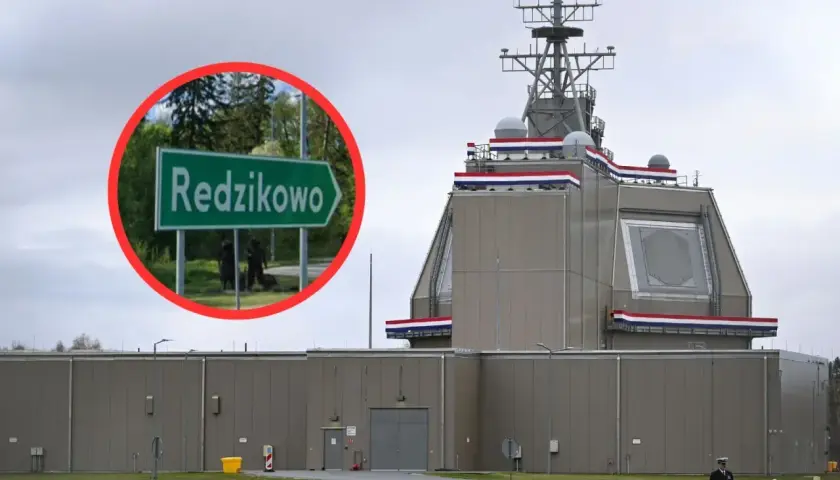 Tablica z napisem "Redzikowo" obok nowoczesnej instalacji wojskowej.