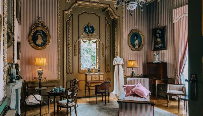 Wnętrze pałacu w Nieborowie. Elegancki salon z portretami, meblami i manekinem w sukni.