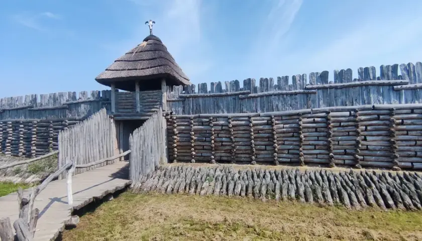Drewniany gród obronny, przypominający rekonstrukcję osady z epoki brązu, z charakterystyczną wieżą i palisadą. To właśnie tutaj znajduje się Janowiec Wielkopolski.