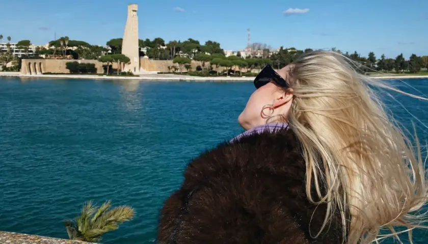 Kobieta z blond włosami podziwia pomnik w Brindisi. Wspaniałe widoki, idealne miejsce, by zobaczyć!