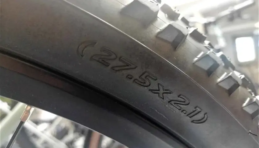 Opona rowerowa 27.5x2.1, gotowa na przygodę. W środku czeka dętka, by zapewnić płynną jazdę.