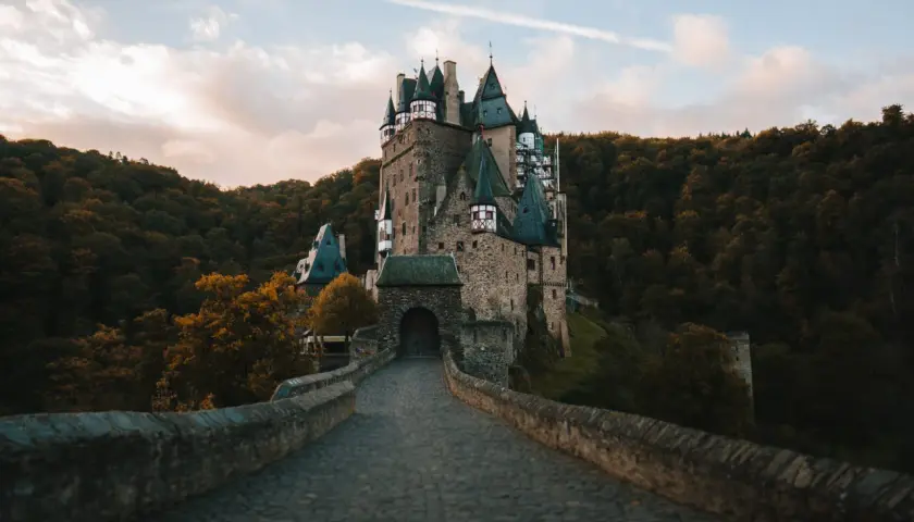 Kamienny most prowadzi do malowniczego zamku Eltz, jednego z najpiękniejszych zamków w Niemczech, otoczonego jesiennym lasem.