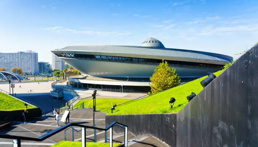 Spodek w Katowicach, ikona województwa śląskiego, otoczony zielenią i nowoczesną architekturą.