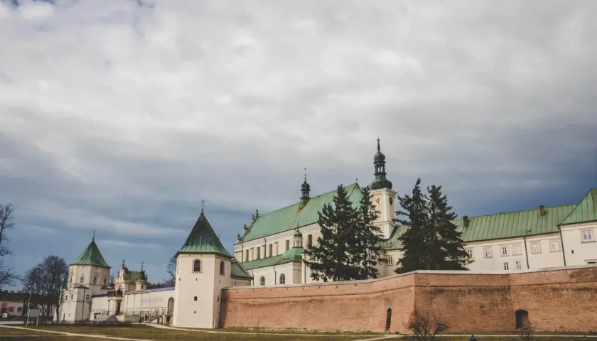 Klasztor w Leżajsku, jedna z głównych atrakcji, z zielonymi dachami i ceglanym murem.