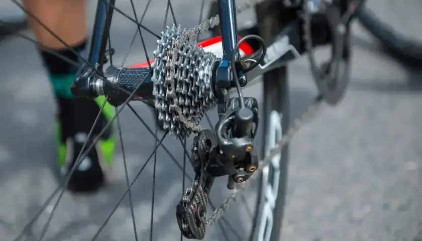 Jak naciągnąć łańcuch w rowerze z przerzutkami Shimano? Widok tylnego koła z kasetą i przerzutką.