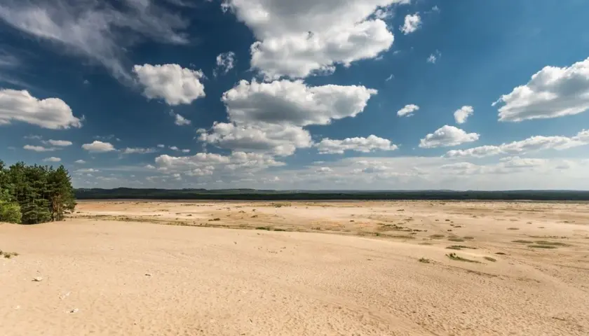 Pustynia Błędowska pod błękitnym niebem z chmurami. Sprawdź pustynia błędowska cennik atrakcji.