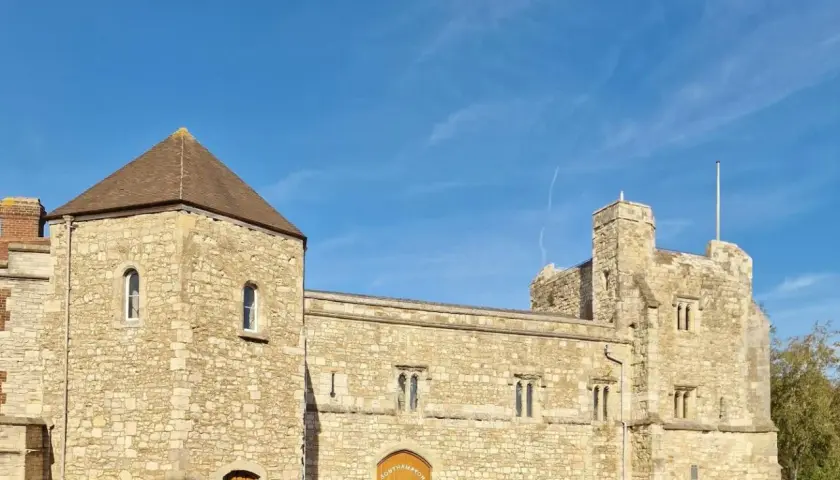 Kamienne budowle w southampton miasto, z wieżą i bramą, pod błękitnym niebem.