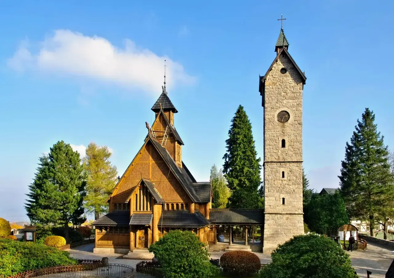Drewniany kościółek i kamienna wieża z zegarem. Idealne miejsce na spokojny weekend w Karpaczu.