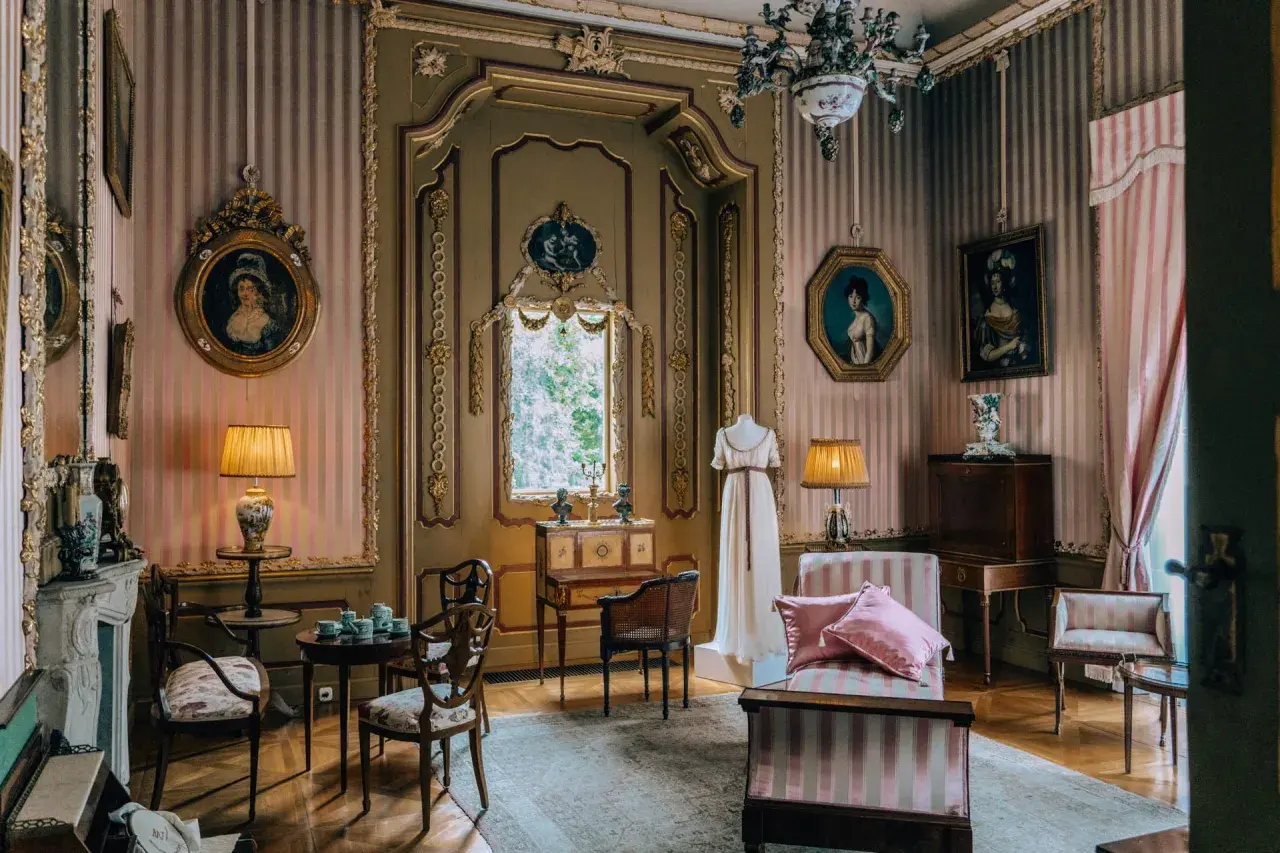 Wnętrze pałacu w Nieborowie. Elegancki salon z portretami, meblami i manekinem w sukni.