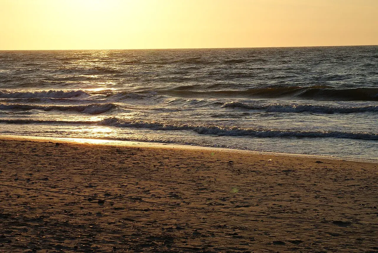 Piękny zachód słońca Sarbinowo. Złote światło odbija się od fal Bałtyku, tworząc magiczny widok na piaszczystej plaży.