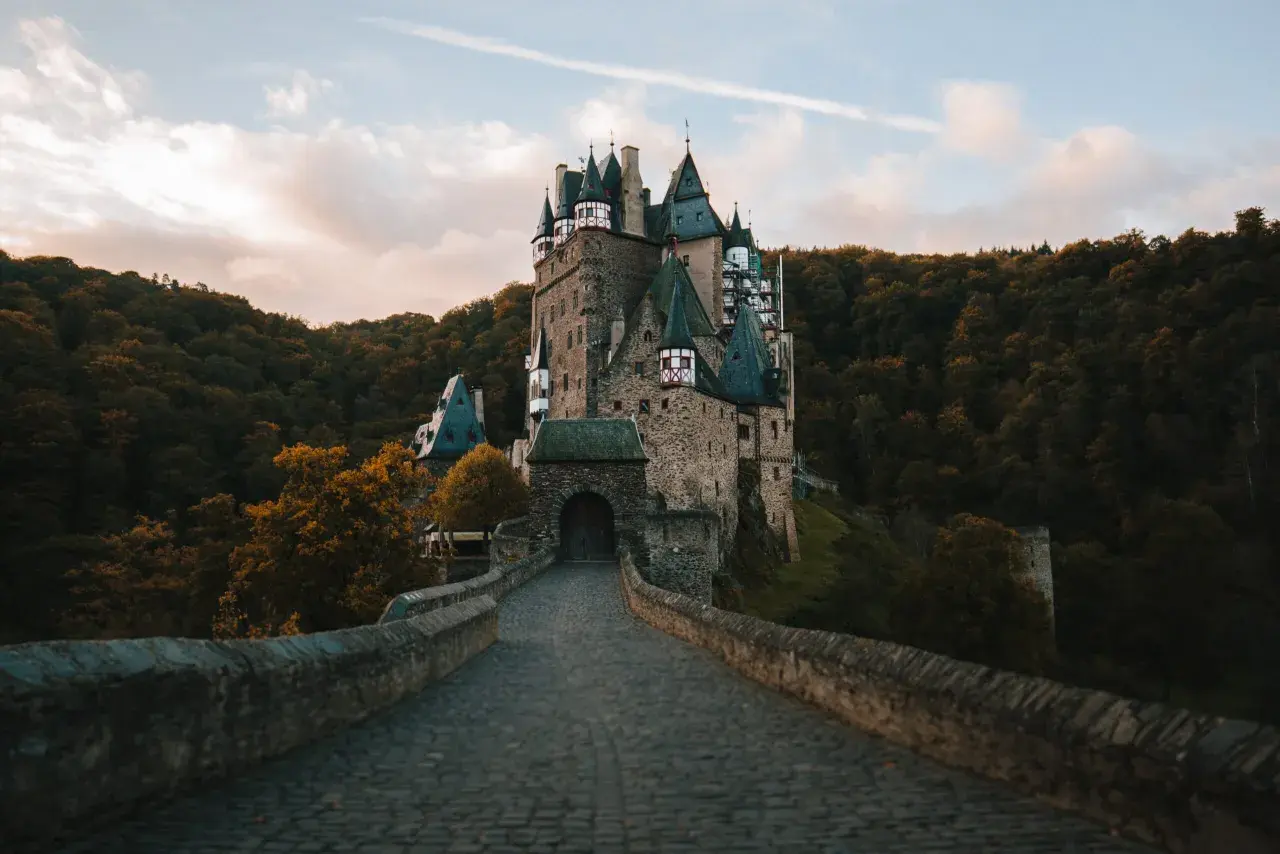 Kamienny most prowadzi do malowniczego zamku Eltz, jednego z najpiękniejszych zamków w Niemczech, otoczonego jesiennym lasem.