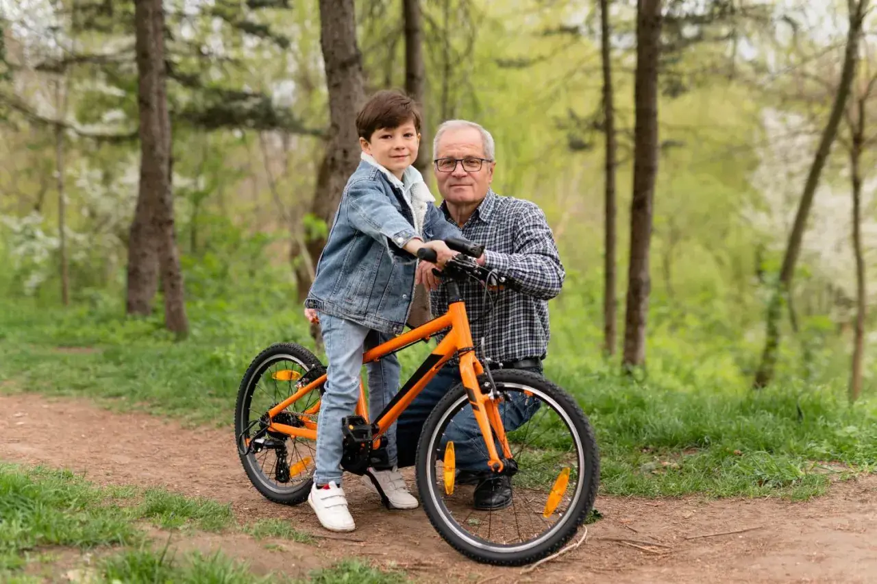 Chłopiec na rowerze 20 cali na jaki wzrost? Dziadek z wnukiem na leśnej ścieżce, gotowi na wspólną przejażdżkę.