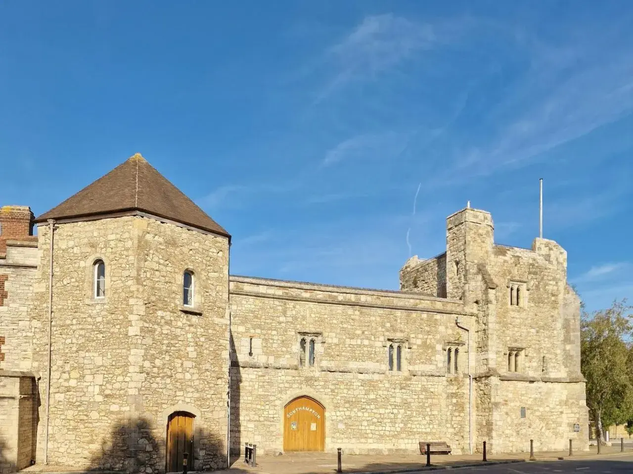 Kamienne budowle w southampton miasto, z wieżą i bramą, pod błękitnym niebem.