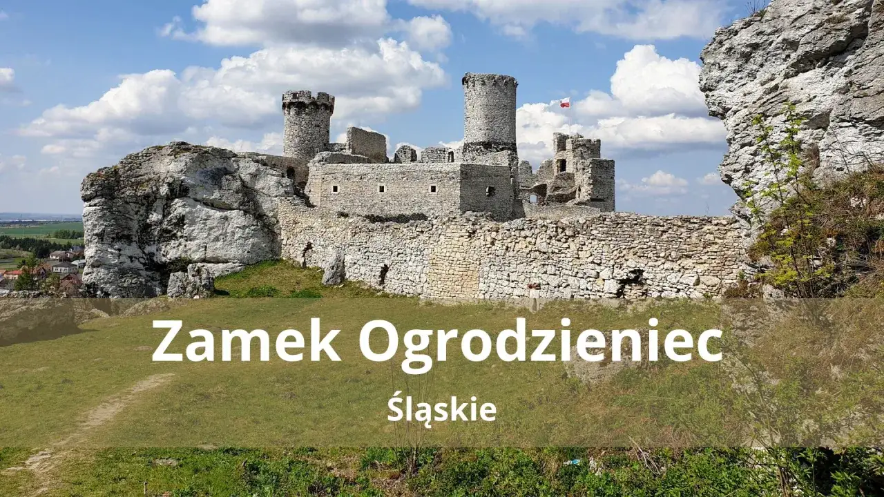 Ruiny zamku Ogrodzieniec na wapiennym wzgórzu, z charakterystycznymi wieżami i murami obronnymi, pod błękitnym niebem.