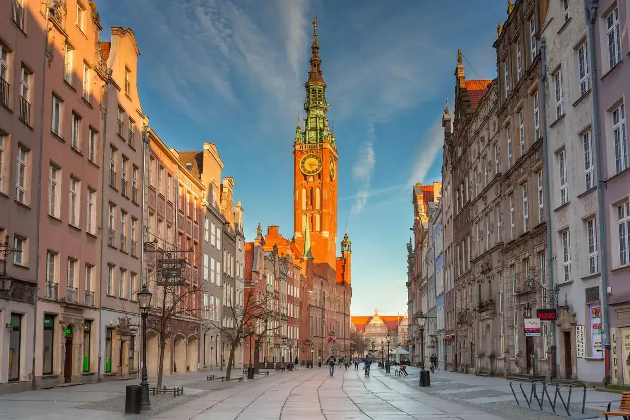 Słoneczna ulica w Gdańsku starówka z Ratuszem Głównym i kolorowymi kamienicami.