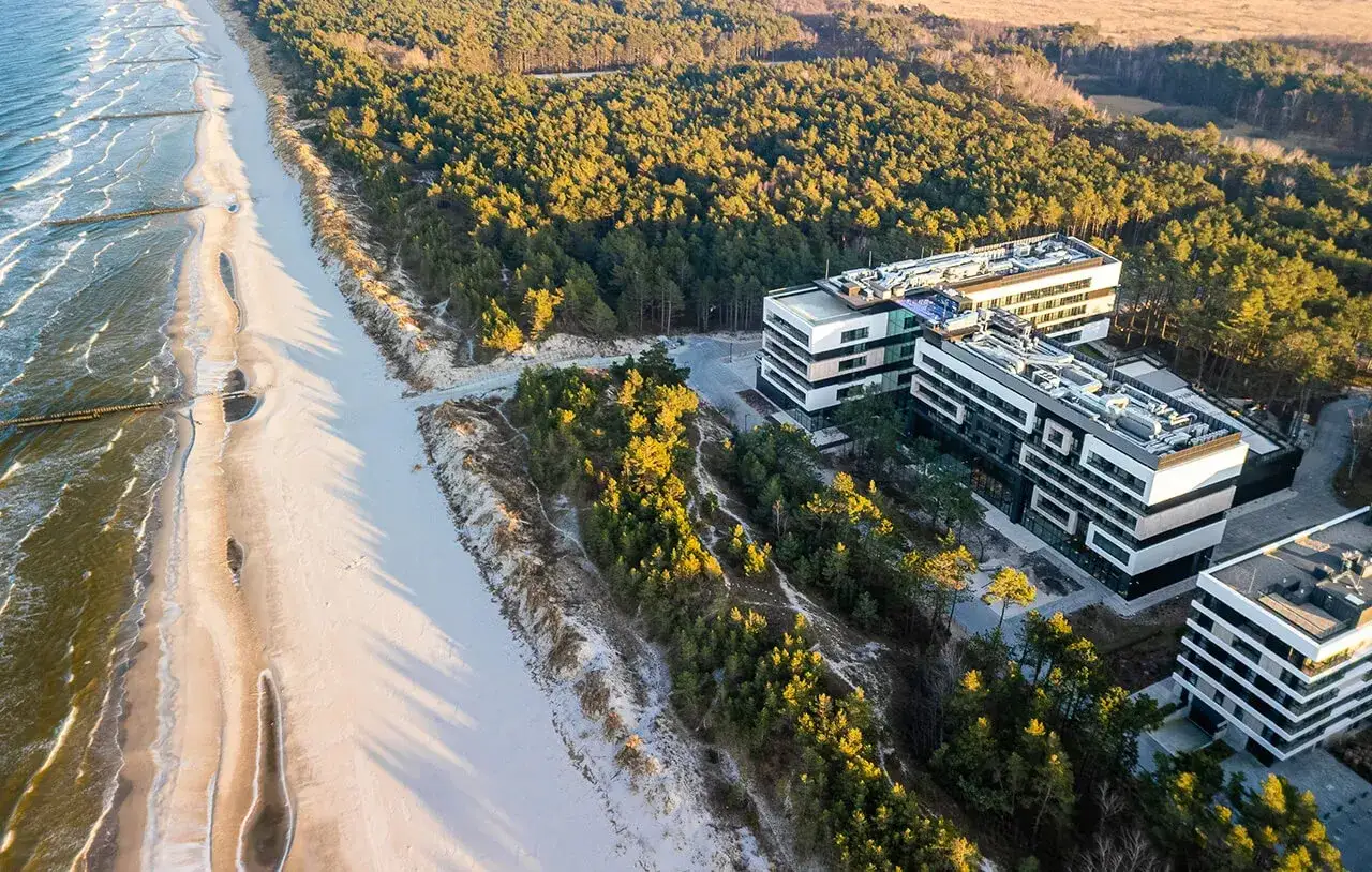 Nowoczesne budynki hotelowe w Rogowie, otoczone sosnowym lasem, tuż przy piaszczystej plaży i morzu.