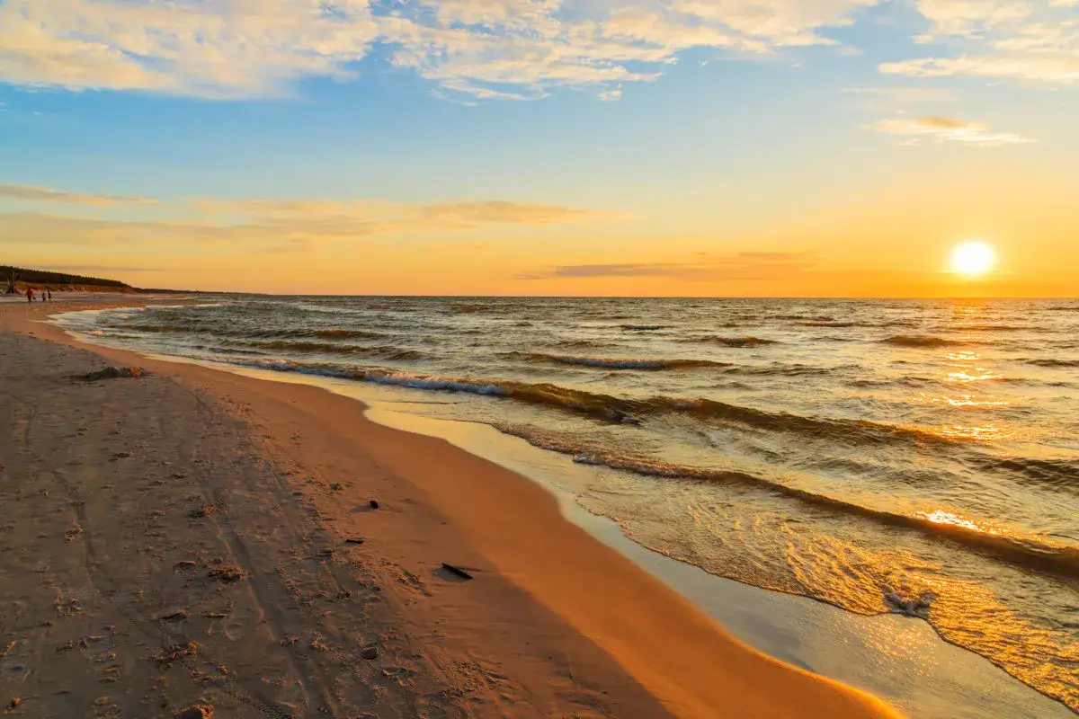 Piękny zachód słońca międzyzdroje. Złote światło odbija się od fal, a pusta plaża zaprasza do spaceru.